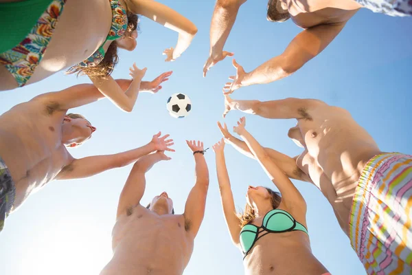 Друзі кидають футбольний м'яч в повітрі — стокове фото