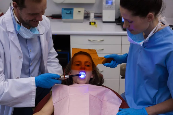 Dentistes examinant un jeune patient avec des outils — Photo