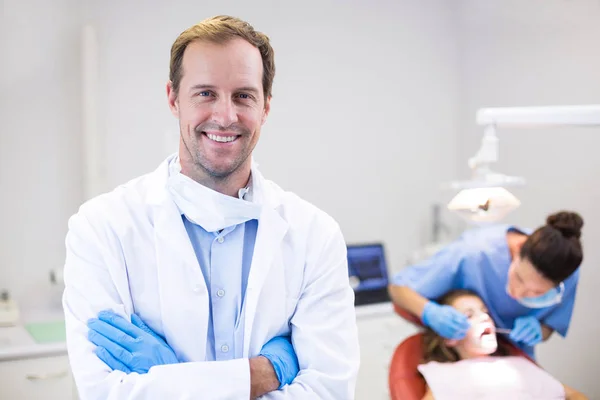 Tandarts permanent met armen gekruist in kliniek — Stockfoto