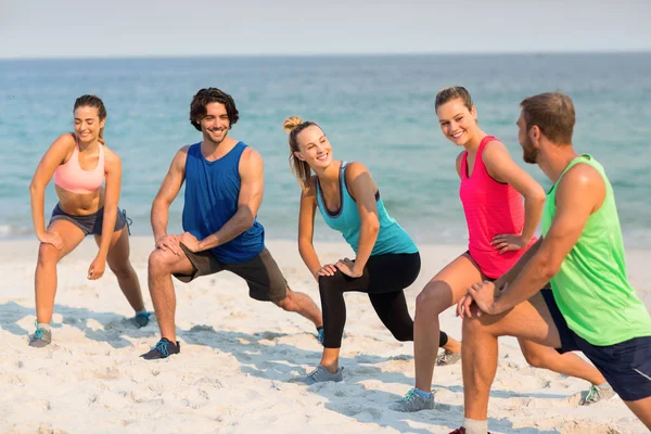 Freunde dehnen sich am Strand — Stockfoto