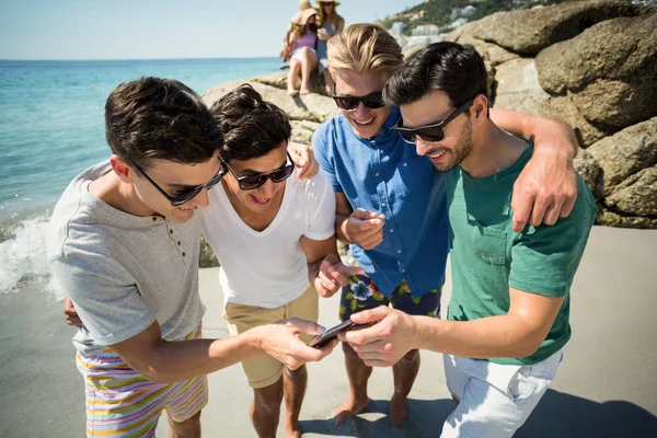 Alegre amigos do sexo masculino olhando no smartphone — Fotografia de Stock