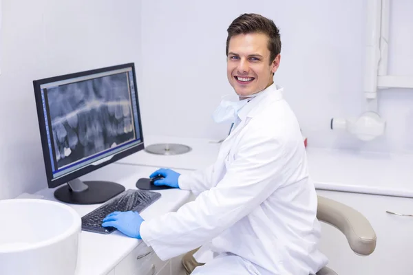 Dentist examining x-ray report on computer — Stock Photo, Image