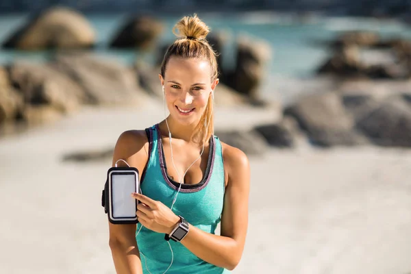 Frau berührt Smartphone an Armbinde — Stockfoto