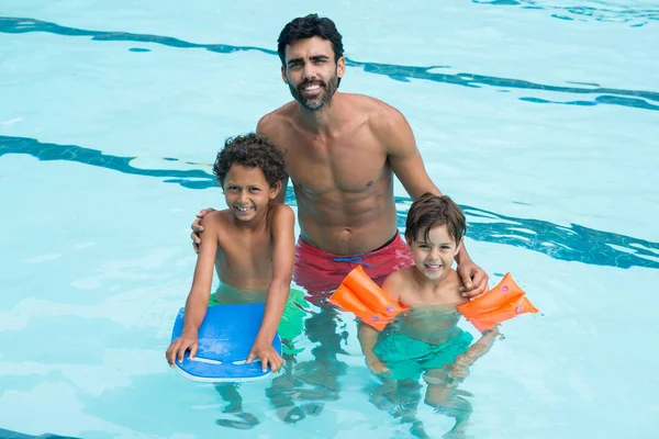 Far och barn som ler i poolen — Stockfoto