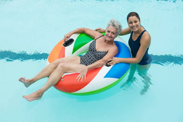 Allenatore femminile e donna anziana sorridente in piscina — Foto Stock