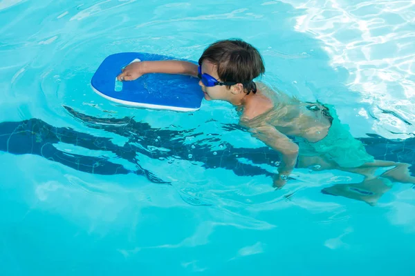 男孩在游泳池里游泳 — 图库照片