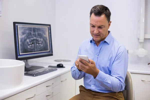 Dentist using mobile phone — Stock Photo, Image