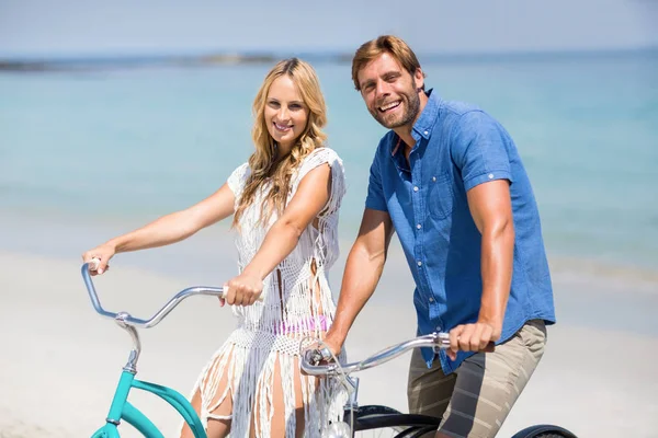 Couple riding bicycles at beach — Stock Photo, Image