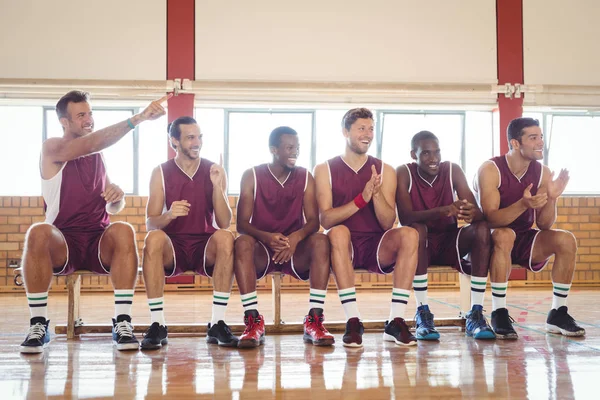 Emocionado jugador de baloncesto sentado en el banco — Foto de Stock