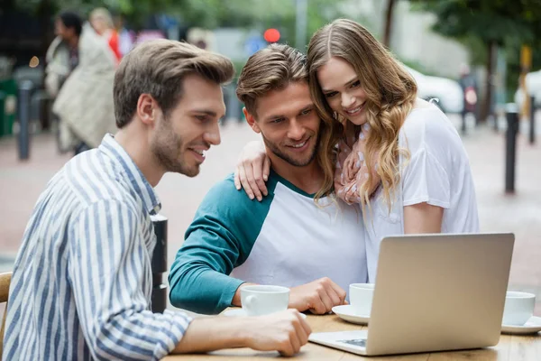 Cuplu vesel cu un prieten folosind laptop — Fotografie, imagine de stoc