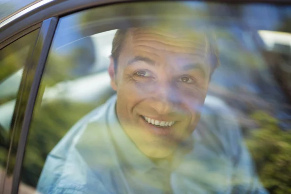 Homme regardant par la fenêtre de la voiture — Photo