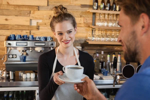 Smiling owner giving coffee to customer — Stock Photo, Image