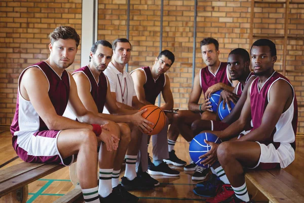 Trainer und Basketballer sitzen auf der Bank — Stockfoto