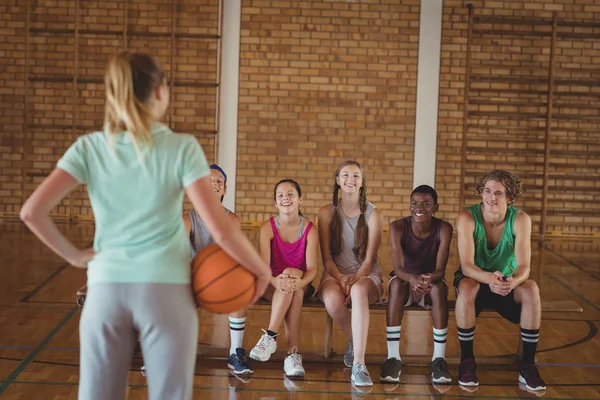 Жінка-тренер стоїть з баскетболом — стокове фото