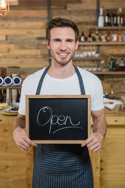 Cameriere in piedi con cartello aperto al bancone — Foto Stock