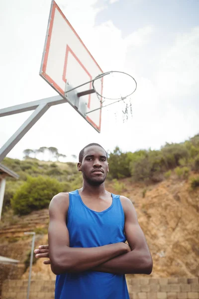 Jugador de baloncesto masculino de pie con los brazos cruzados —  Fotos de Stock