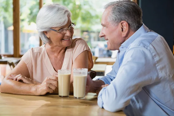 Pareja mayor interactuando mientras toma café — Foto de Stock