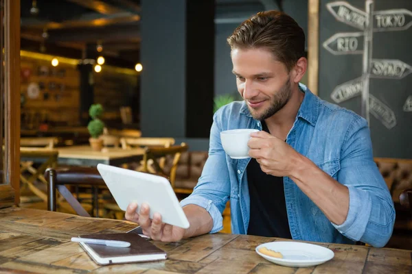 Hombre usando la tableta mientras bebe café —  Fotos de Stock