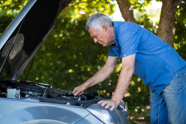 Старший человек проверяет двигатель поломки автомобиля — стоковое фото