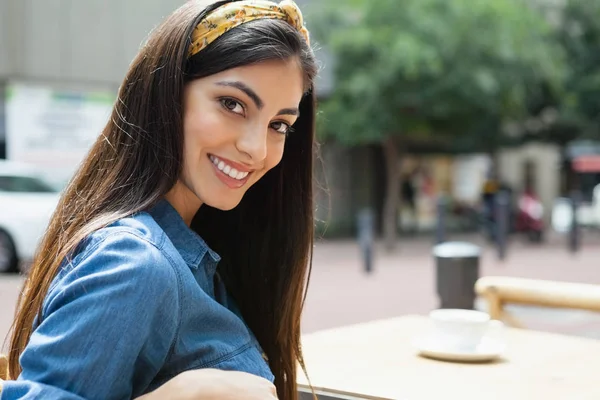 Kvinnan sitter på stol på trottoaren café — Stockfoto