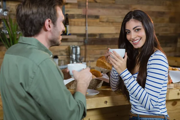 Vrouw met koffie bij balie — Stockfoto