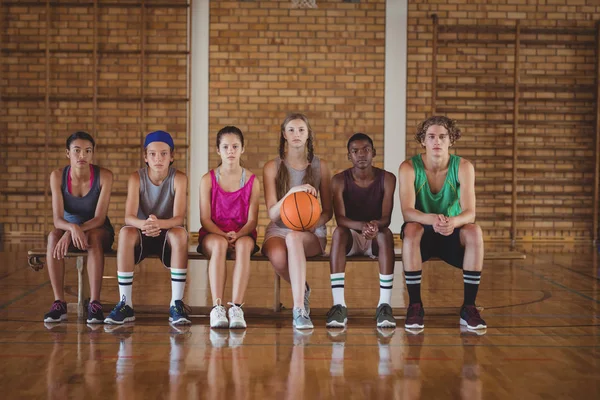 Middelbare schoolkinderen zitten op een bankje — Stockfoto