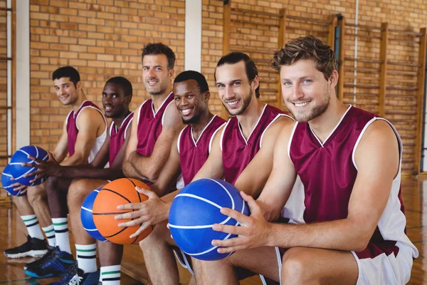 Basketball players on bench with basketball — Stock Photo, Image