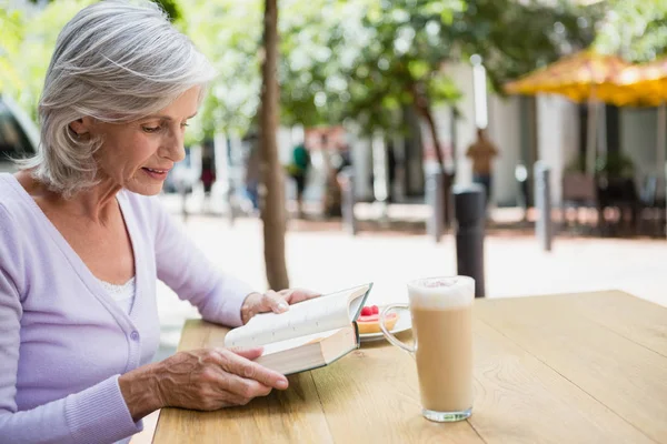 Starsza kobieta czyta książkę. — Zdjęcie stockowe