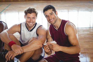 basketball players using mobile while relaxing clipart