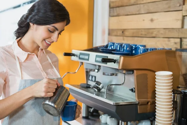 Serveerster gieten koffie in Beker — Stockfoto