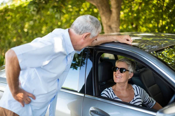 Homem sênior falando com mulher no carro — Fotografia de Stock