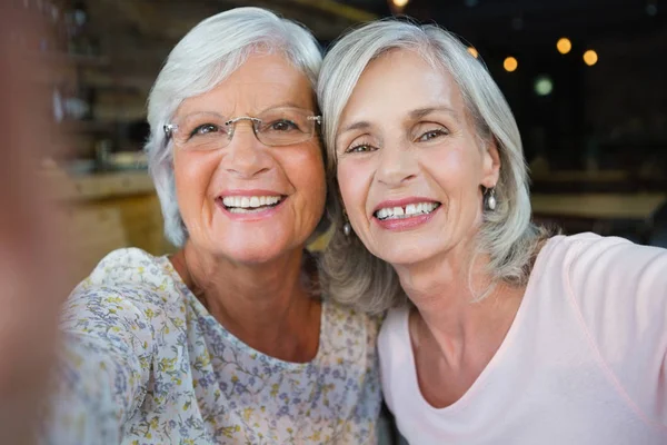 Две пожилые женщины сидят вместе в кафе — стоковое фото