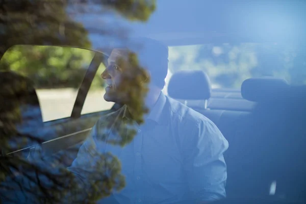 Man sitting on back seat  in car — Stock Photo, Image