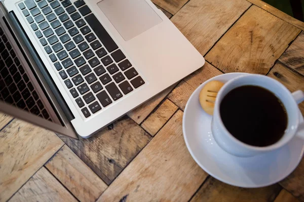 Laptop e xícara de café na mesa — Fotografia de Stock