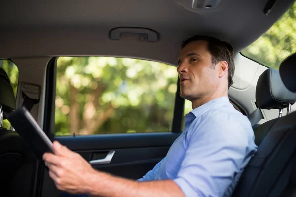 Mężczyznę trzymającego cyfrowe tabletki w samochodzie — Zdjęcie stockowe