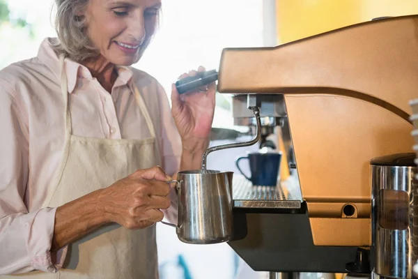 Старша офіціантка використовує кавоварку — стокове фото