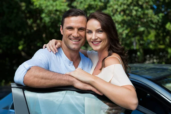 Pareja apoyada en la puerta del coche — Foto de Stock