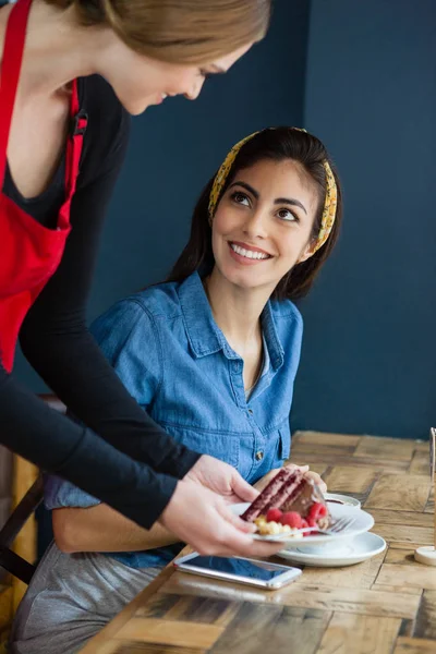 Smiling owner serving sweet food — Stock Photo, Image