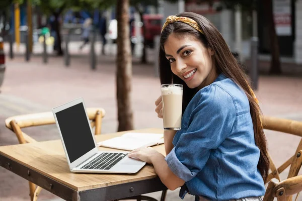 Mulher usando laptop enquanto sentado no café — Fotografia de Stock