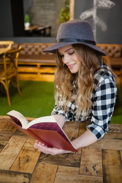 Γυναίκα φοράει καπέλο ανάγνωση βιβλίων — Φωτογραφία Αρχείου