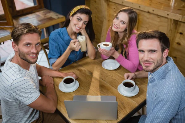 Happy přátelé s kávou u stolu — Stock fotografie