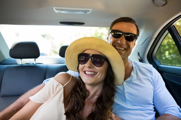 Wesoły para, noszenie okularów przeciwsłonecznych w samochodzie — Zdjęcie stockowe
