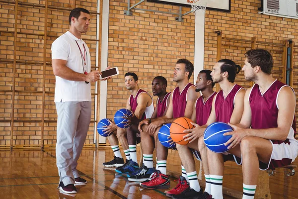 Entrenador interactuando con jugadores de baloncesto — Foto de Stock