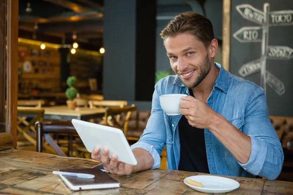 Un bărbat care utilizează tabletă în timp ce bea cafea — Fotografie, imagine de stoc