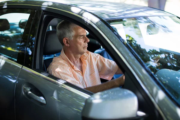 Senior man in auto — Stockfoto