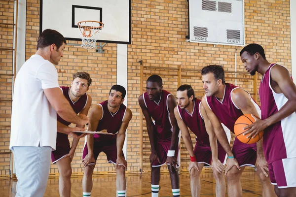 Treinador explicando plano de jogo para jogadores de basquete — Fotografia de Stock