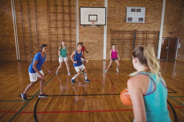 Střední školy děti hraje basketbal — Stock fotografie