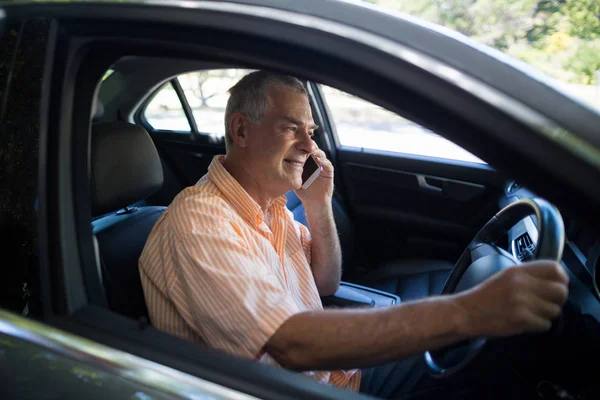 Senior man talking on phone in car — Stock Photo, Image