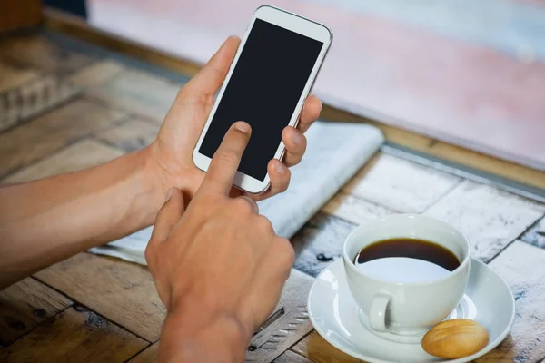 Frau hält Telefon an Kaffeetasse — Stockfoto