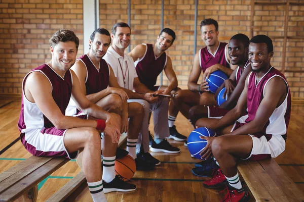 Treinador e jogador de basquete sentado no banco — Fotografia de Stock